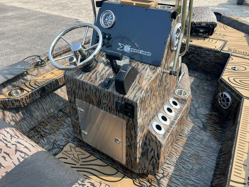 Slide: The Image of 2025 Xpress H20B boat interior with camouflage design and steering console. - 12