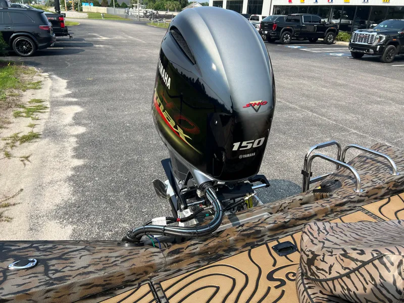 Slide: The Image of 2025 Xpress H20B boat with Yamaha 150 outboard motor in parking lot. - 14
