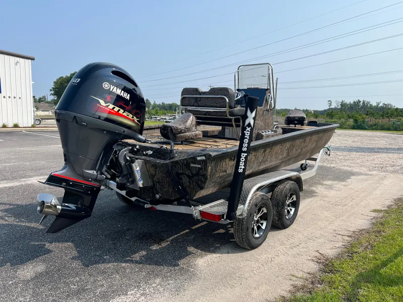 Slide: The Image of 2025 Xpress H20B boat with Yamaha engine on trailer in parking lot. - 6