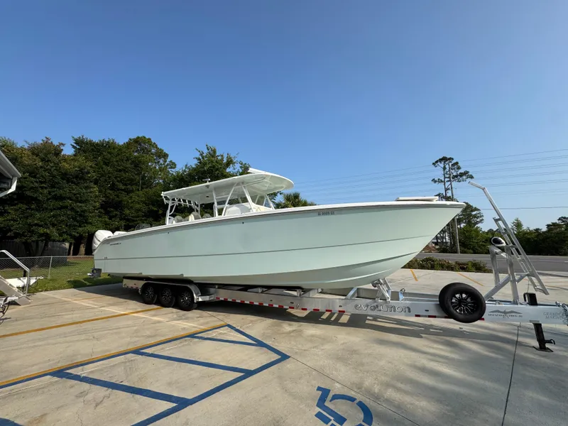 Slide: The Image of 2022 Invincible 40 Catamaran on trailer, parked outdoors under clear sky. - 10