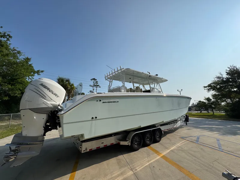 Slide: The Image of 2022 Invincible 40 Catamaran on trailer, parked outdoors under clear sky. - 12