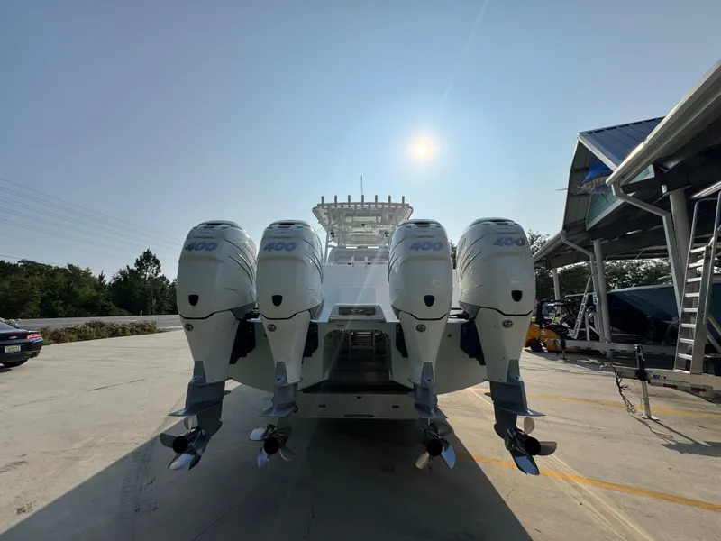 Slide: The Image of 2022 Invincible 40 Catamaran with four powerful outboard engines, docked under clear sky. - 14