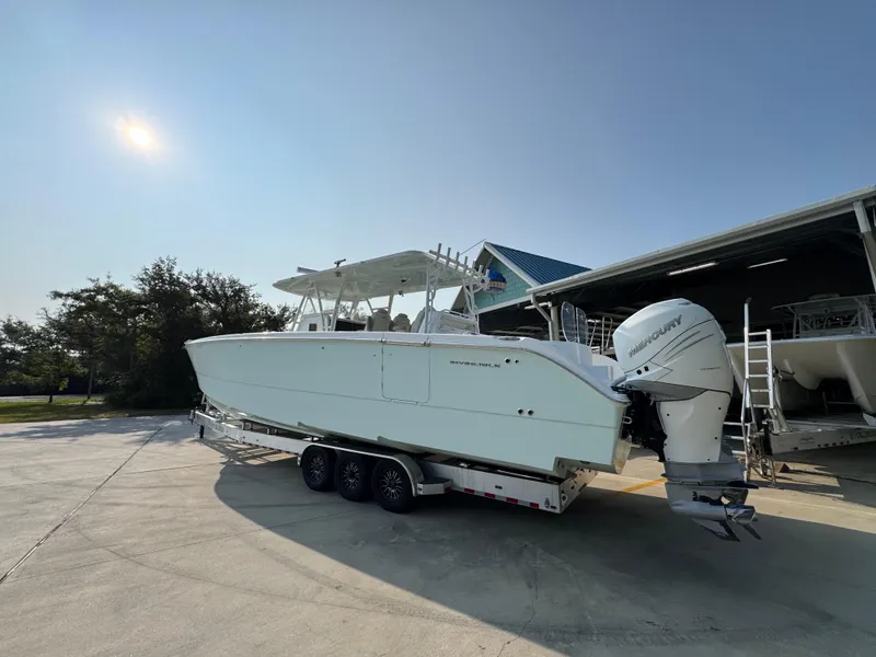 Slide: The Image of 2022 Invincible 40 Catamaran on trailer, parked outdoors near a building. - 16