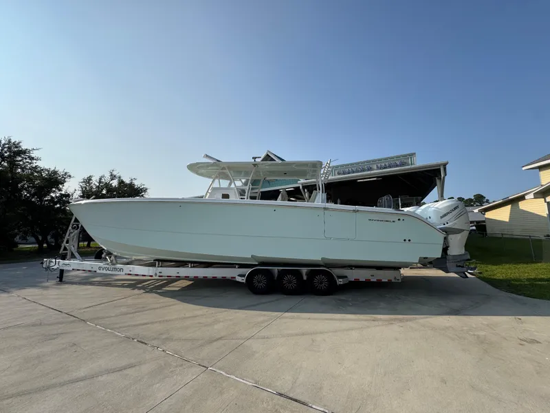 Slide: The Image of 2022 Invincible 40 Catamaran on trailer, parked outdoors under clear sky. - 18