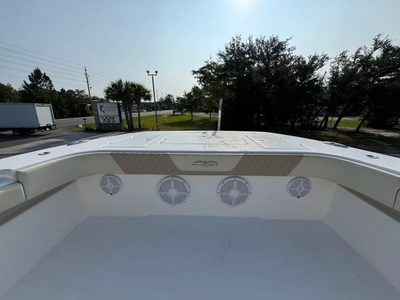 Slide: The Image of 2022 Invincible 40 Catamaran deck with speakers, surrounded by trees and road. - 20