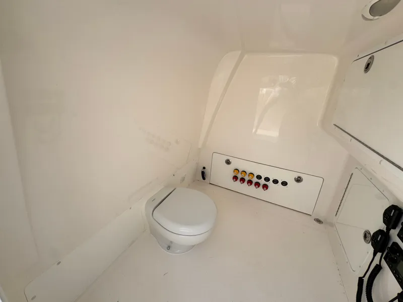 Slide: The Image of Interior of 2022 Invincible 40 Catamaran showing a compact marine toilet and control panel. - 26