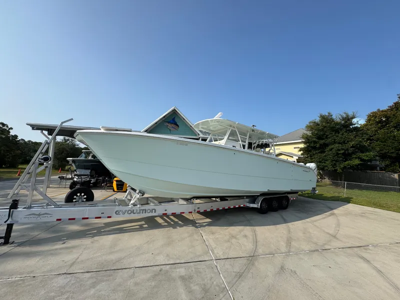 Slide: The Image of 2022 Invincible 40 Catamaran on trailer, parked outdoors under clear blue sky. - 3