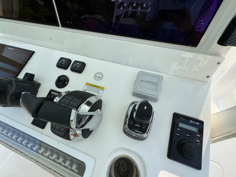 Slide: The Image of Control panel of 2022 Invincible 40 Catamaran with throttle and navigation controls. - 32