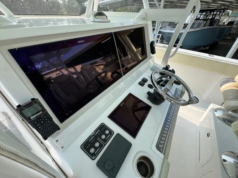 Slide: The Image of Control panel of 2022 Invincible 40 Catamaran with steering wheel and navigation screens. - 34