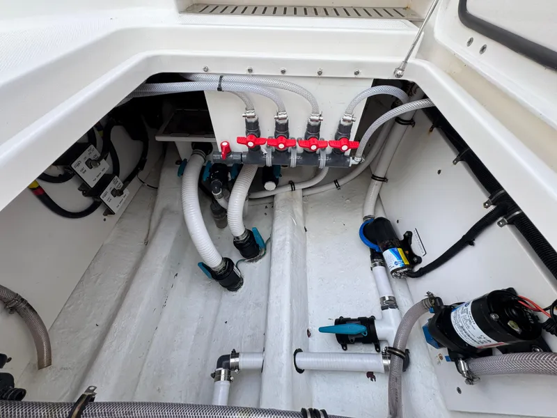 Slide: The Image of Engine compartment of a 2022 Invincible 40 Catamaran with visible hoses and valves. - 44