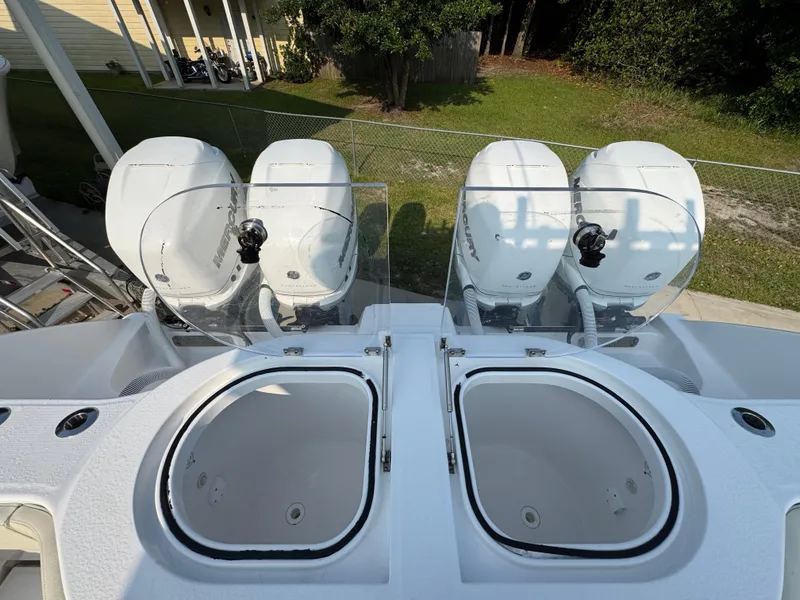 Slide: The Image of 2022 Invincible 40 Catamaran with dual outboard engines and live wells, docked outdoors. - 46