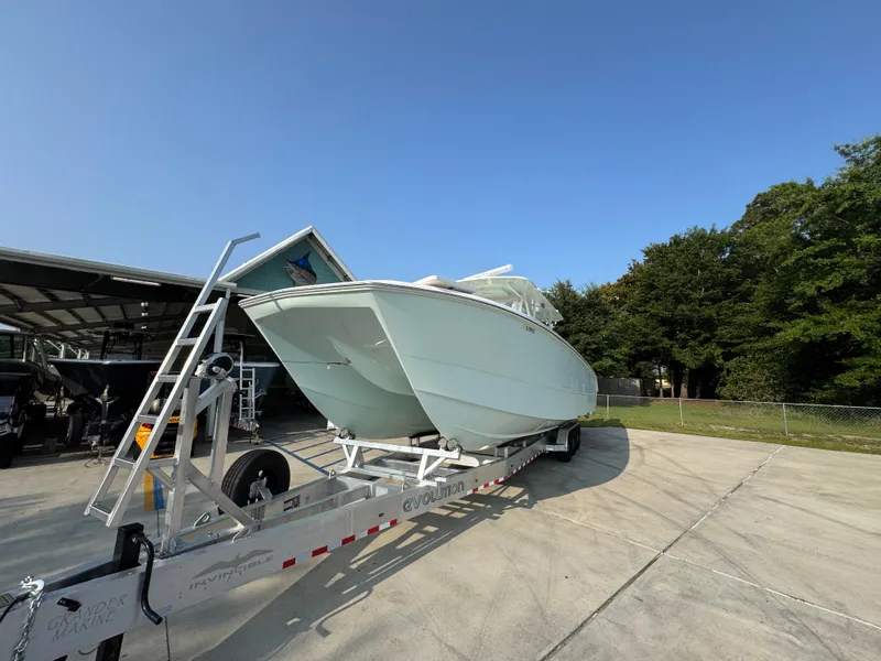 Slide: The Image of 2022 Invincible 40 Catamaran on trailer, parked outdoors under clear blue sky. - 5