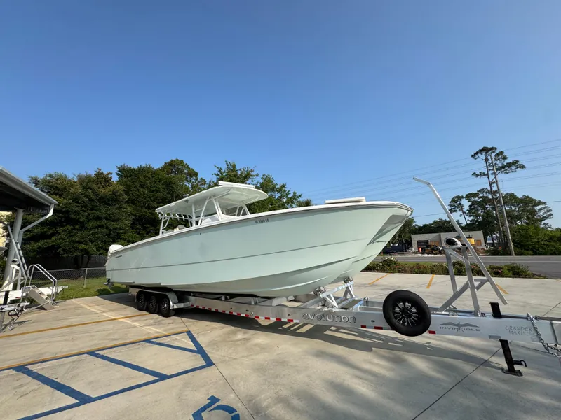 Slide: The Image of 2022 Invincible 40 Catamaran on trailer, parked outdoors under clear blue sky. - 9