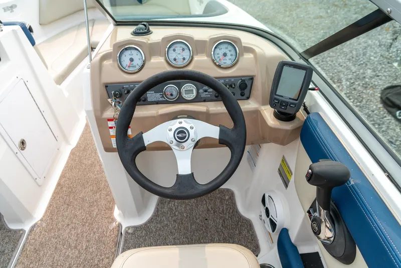 Slide: The Image of 2014 Chaparral 21 Ski & Fish H2O boat dashboard with steering wheel and gauges. - 14