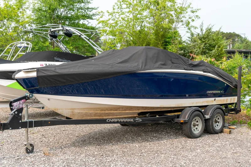 Slide: The Image of 2014 Chaparral 21 Ski & Fish H2O boat covered on a trailer, parked outdoors. - 3