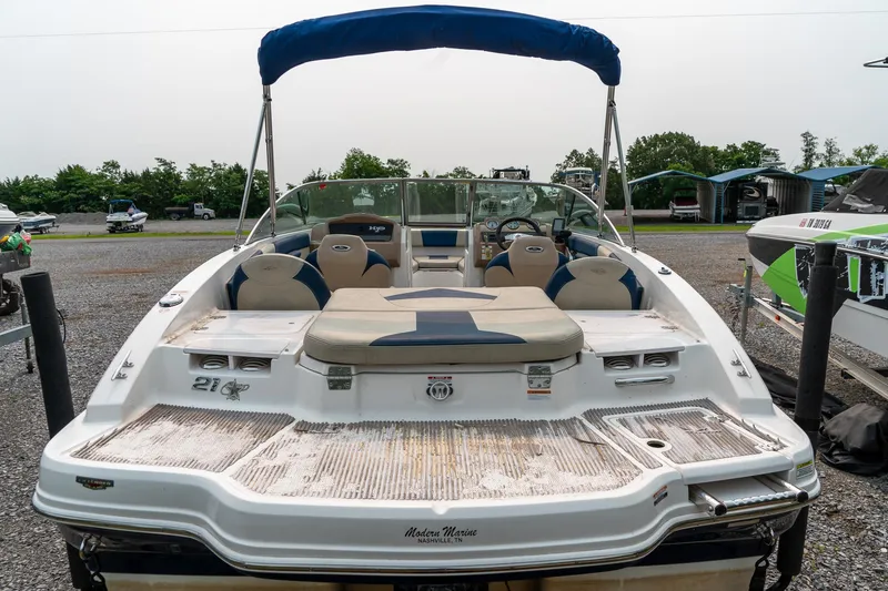 Slide: The Image of 2014 Chaparral 21 Ski & Fish H2O boat with blue canopy, parked on gravel. - 9