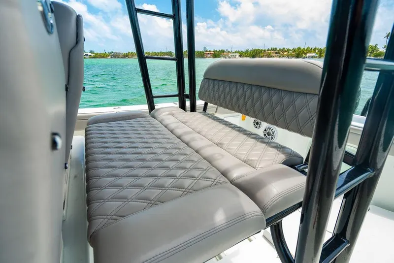 Slide: The Image of 2015 Yellowfin CC boat with cushioned seating, black frame, and ocean view. - 10