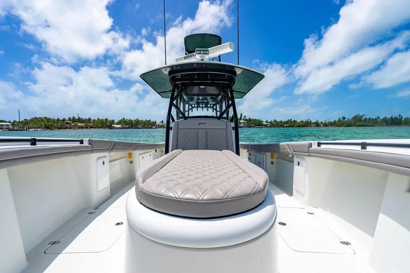 Slide: The Image of 2015 Yellowfin CC boat with cushioned seating, set against a scenic ocean backdrop. - 12