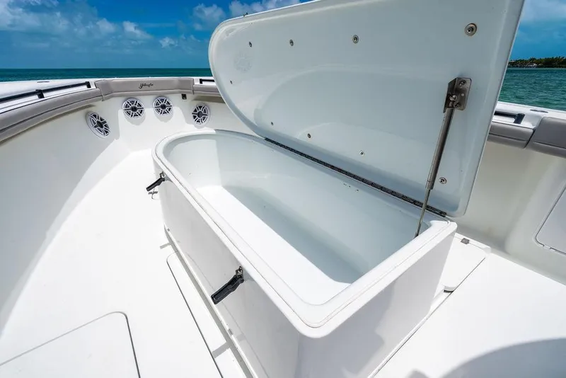Slide: The Image of 2015 Yellowfin CC boat with open storage compartment, ocean view in background. - 14