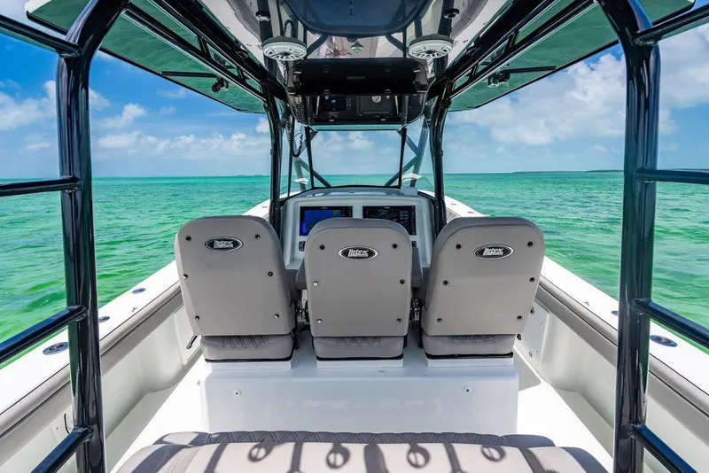 Slide: The Image of 2015 Yellowfin CC boat interior with ocean view, featuring three seats and navigation equipment. - 17