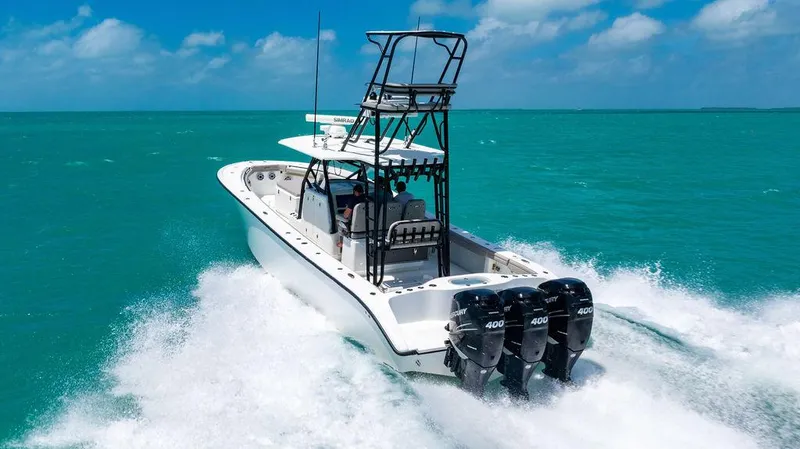 Slide: The Image of 2015 Yellowfin CC boat cruising on turquoise ocean with triple outboard engines. - 2