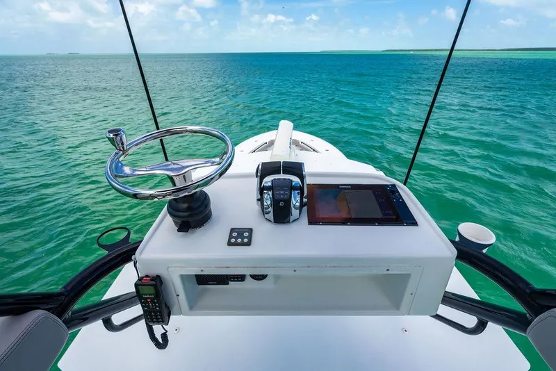 Slide: The Image of 2015 Yellowfin CC boat helm with ocean view, featuring steering wheel and navigation controls. - 22