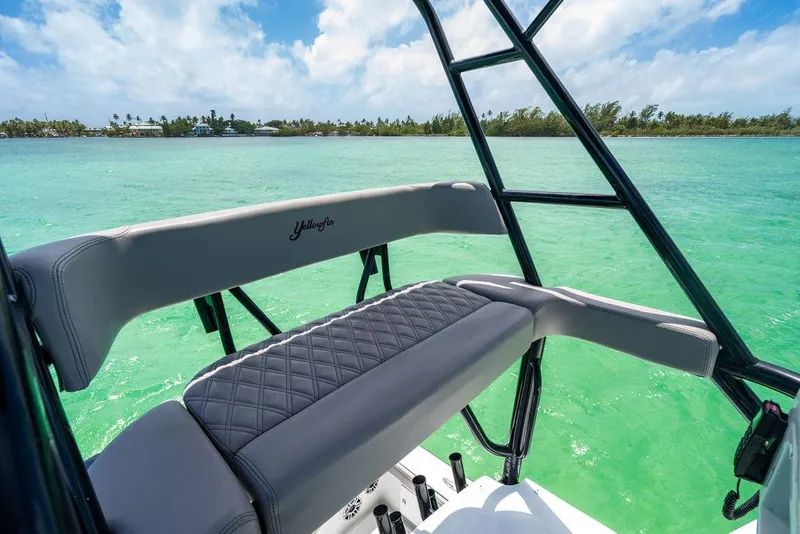 Slide: The Image of 2015 Yellowfin CC boat with cushioned seating, overlooking turquoise waters and clear skies. - 23