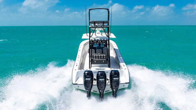 Slide: The Image of 2015 Yellowfin CC boat with triple 400 engines cruising on turquoise water. - 24