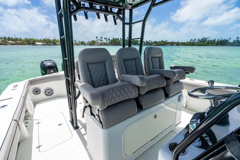Slide: The Image of 2015 Yellowfin CC boat interior with plush seating, steering wheel, and ocean view. - 6