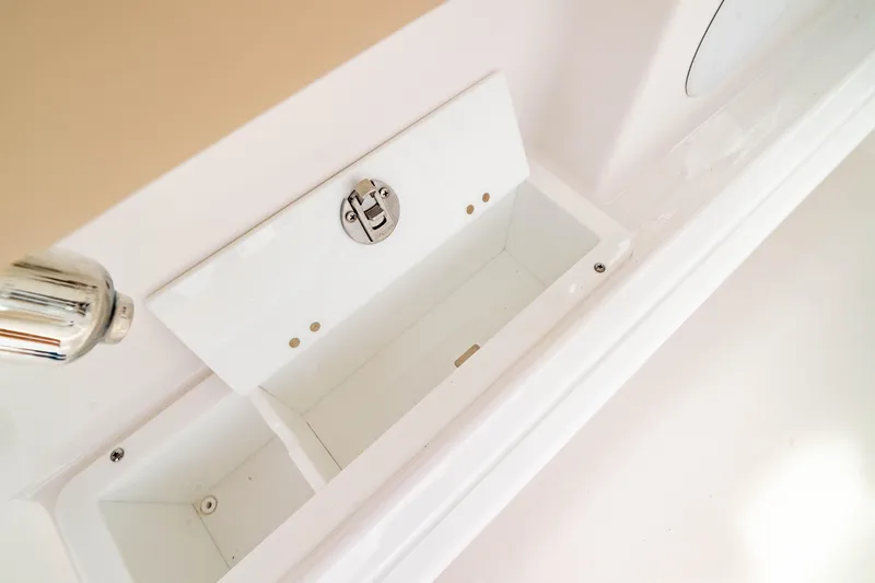 Slide: The Image of Storage compartment on 2026 Edgewater 248 CX boat, featuring a secure latch and white interior. - 15