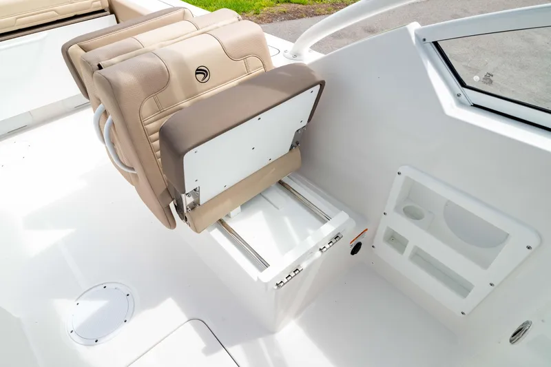 Slide: The Image of 2026 Edgewater 248 CX boat interior with beige seating and storage compartment. - 17