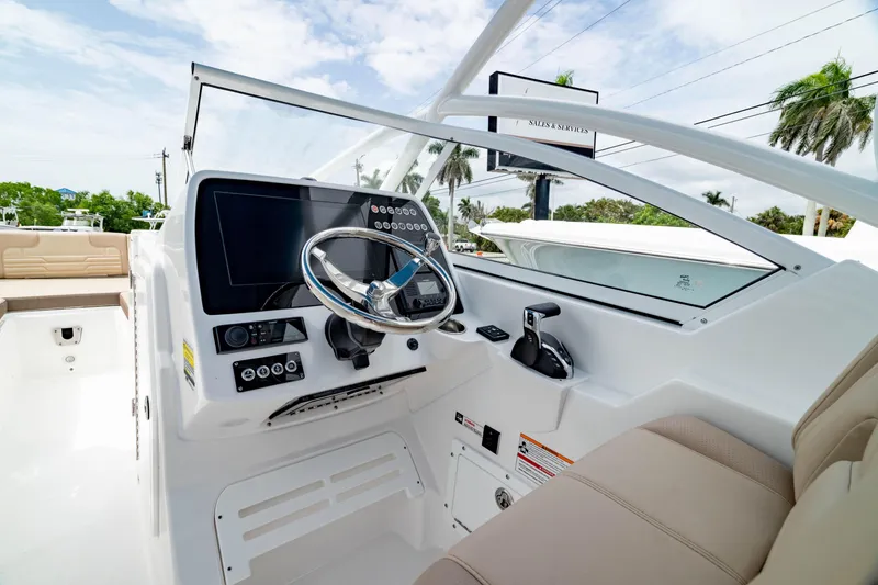 Slide: The Image of 2026 Edgewater 248 CX boat cockpit with modern steering and controls. - 2