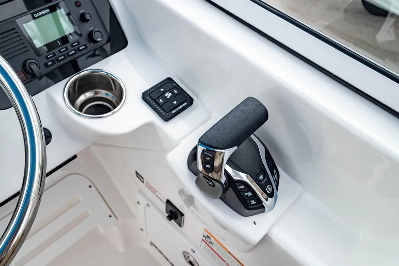 Slide: The Image of 2026 Edgewater 248 CX boat cockpit with throttle, cup holder, and control panel. - 24