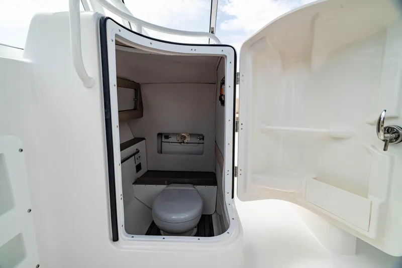 Slide: The Image of 2026 Edgewater 248 CX boat interior with compact marine toilet and storage. - 34