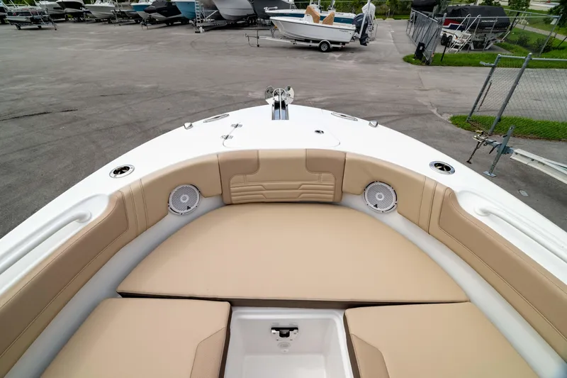 Slide: The Image of 2026 Edgewater 248 CX boat with beige seating in a marina setting. - 40