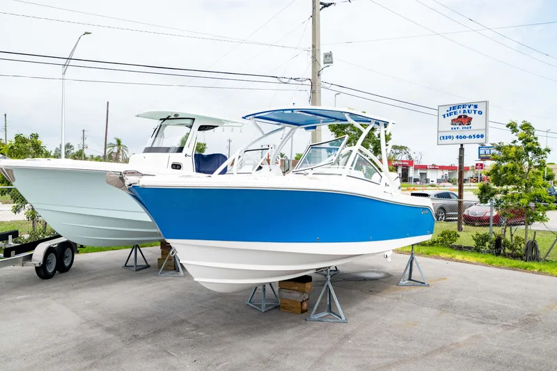 Slide: The Image of 2026 Edgewater 248 CX boat displayed outdoors on a lot. - 45