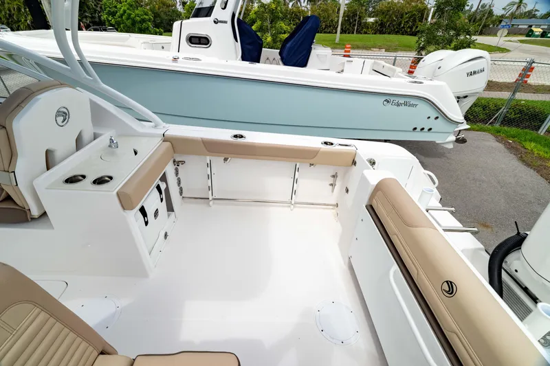 Slide: The Image of 2026 Edgewater 248 CX boat interior with beige seating and white deck. - 9