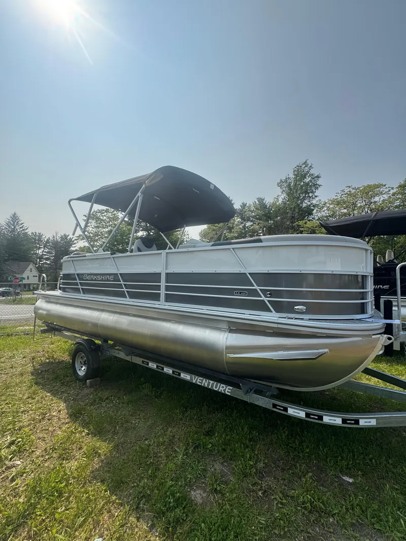 The Image of 2025 Berkshire 22RFX LE pontoon boat on trailer, sunny day, grassy area. - 0