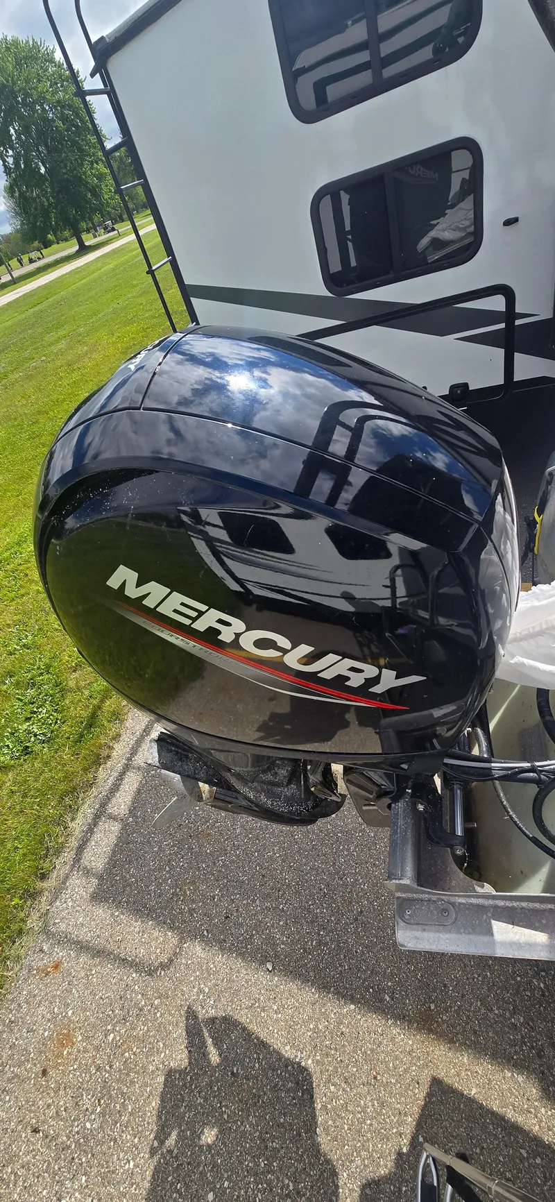 Slide: The Image of Mercury outboard motor on 2021 Crest Classic LX 220 SLC boat, parked near RV. - 16