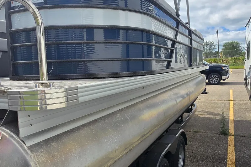 Slide: The Image of 2021 Crest Classic LX 220 SLC pontoon boat on trailer in parking lot. - 3