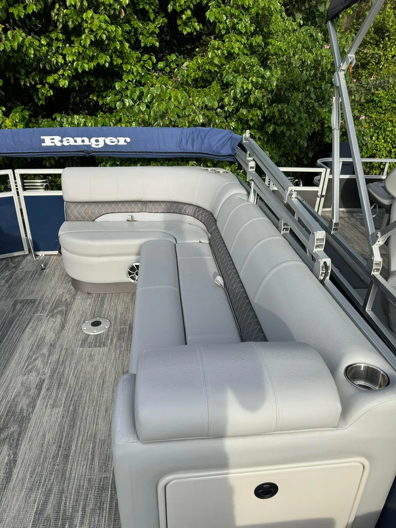 Slide: The Image of 2024 Ranger Reata 220C pontoon boat with spacious seating and sleek design. - 2