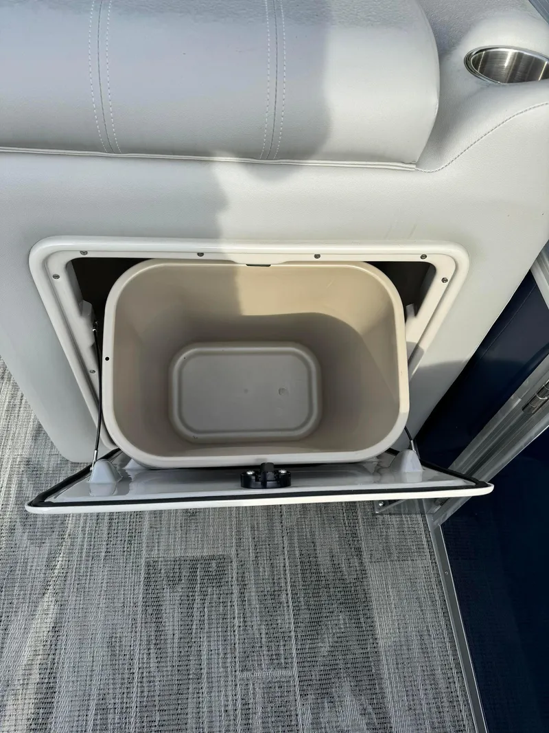 Slide: The Image of 2024 Ranger Reata 220C boat storage compartment with open lid, showcasing interior space. - 4