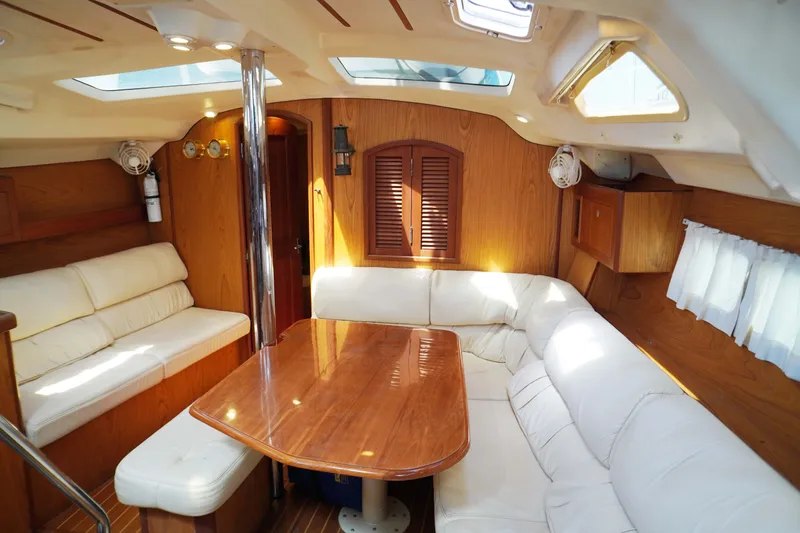 Slide: The Image of Interior of 2000 Hunter Passage 420 yacht with wooden table and white seating. - 26