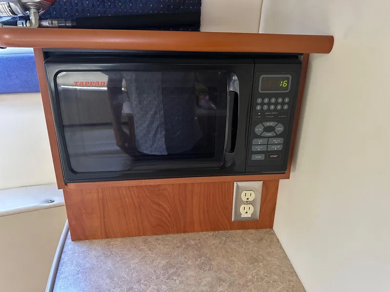 Slide: The Image of Microwave in 2008 Bayliner 265 boat interior, with wooden paneling and electrical outlet. - 11