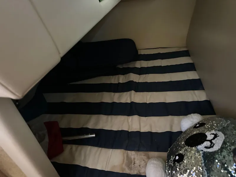 Slide: The Image of Interior cabin of 2008 Bayliner 265 with striped bedding and plush toy. - 9