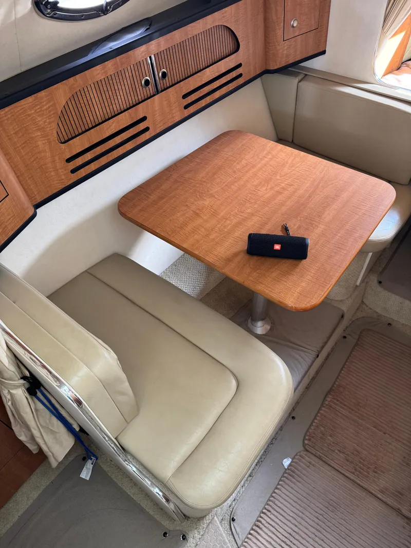 Slide: The Image of 2006 Sea Ray 280 Sundancer cabin with wooden table and beige seating. - 10