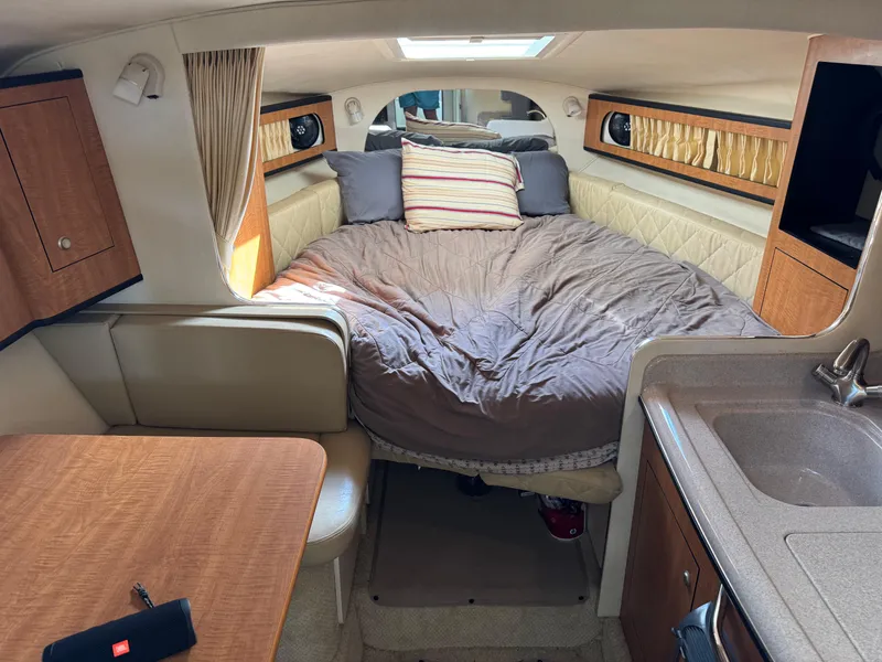 Slide: The Image of 2006 Sea Ray 280 Sundancer cabin with cozy bed, kitchenette, and seating area. - 11