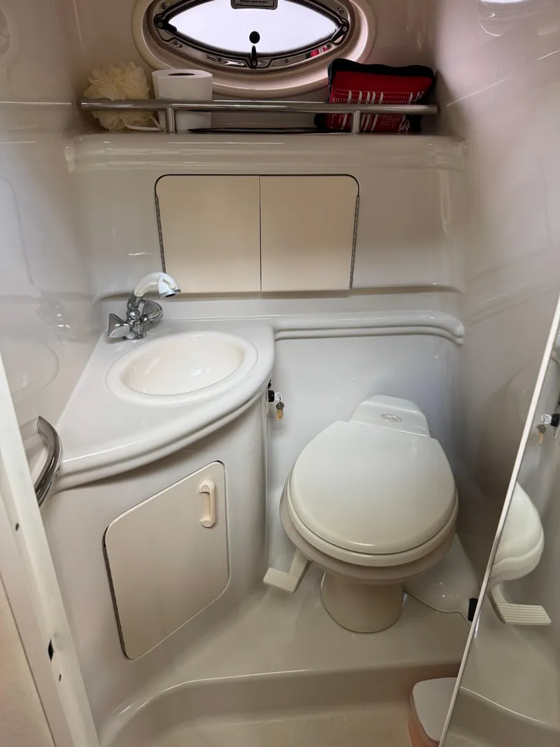 Slide: The Image of 2006 Sea Ray 280 Sundancer bathroom with sink, toilet, and storage cabinets. - 12