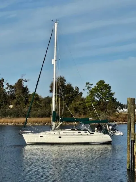 The Image of Jeanneau Sun Odyssey 36.2 sailboat from 2000 on calm water, with trees in the background. - 0