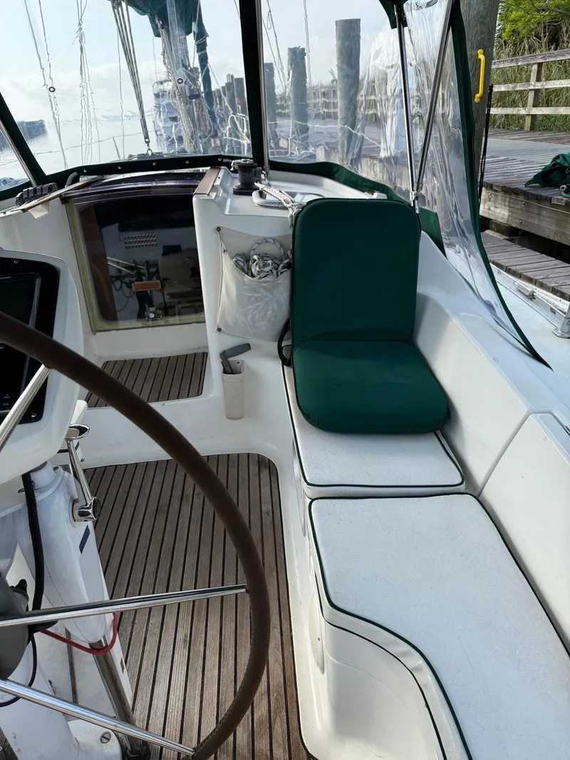Slide: The Image of Cockpit of 2000 Jeanneau Sun Odyssey 36.2 sailboat with green cushion and wooden flooring. - 11